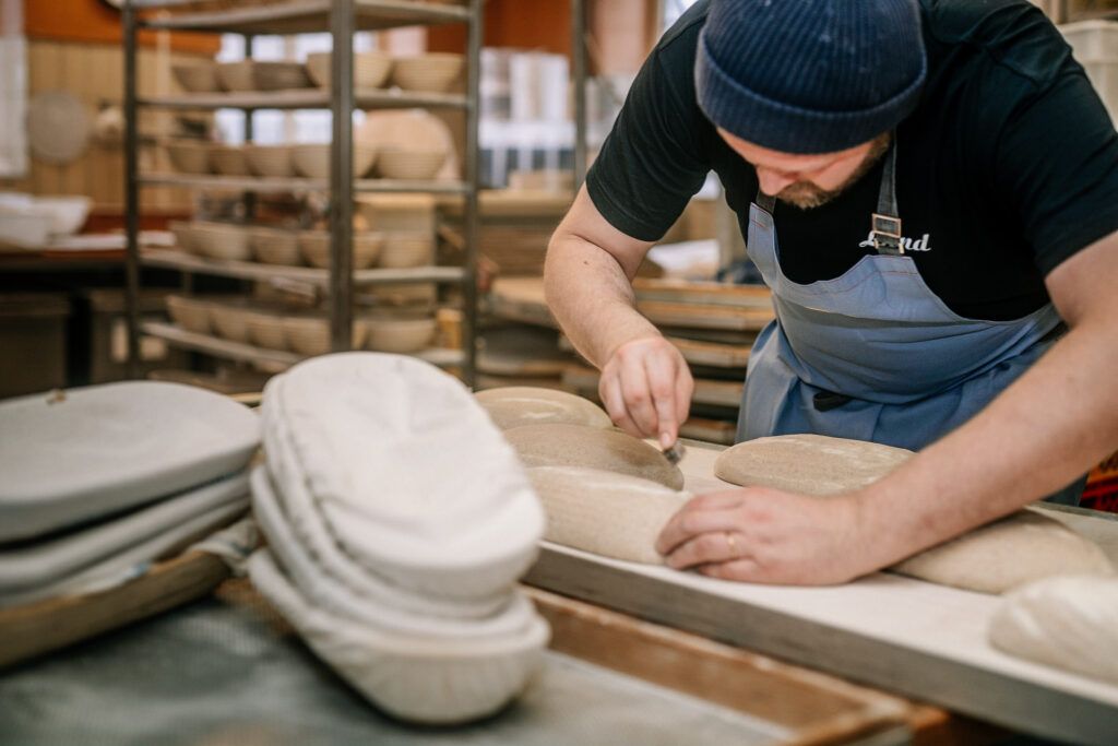 Ein Bäcker backt Brot in einer Fabrik.